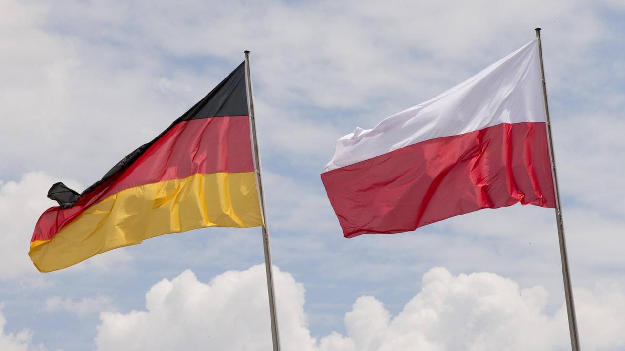Die deutsche und die polnische Nationalflagge sind gegen den Himmel zu sehen in Berlin. Die deutsche und die polnische Nationalflagge sind gegen den Himmel zu sehen in Berlin.