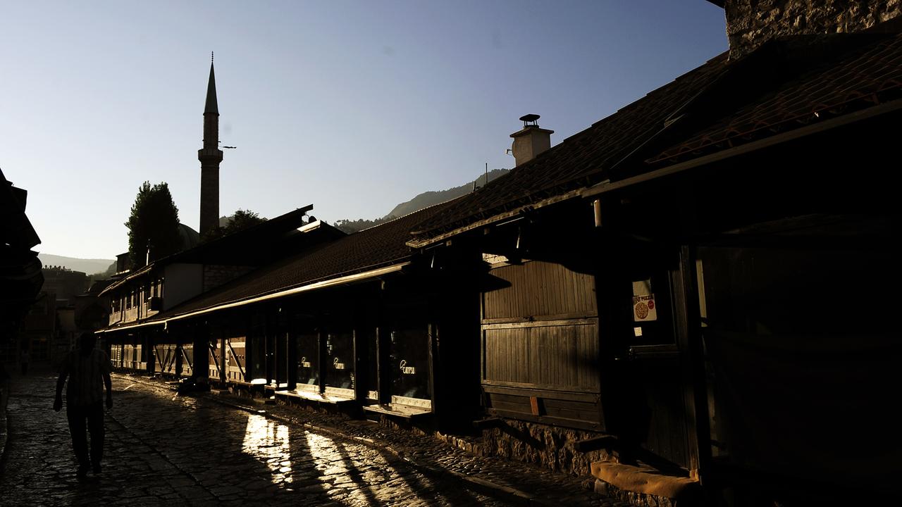 Blick in eine Straße in der Altstadt von Sarajewo mit dem Minarett einer Moschee im Gegenlicht Blick in eine Straße in der Altstadt von Sarajewo mit dem Minarett einer Moschee im Gegenlicht
