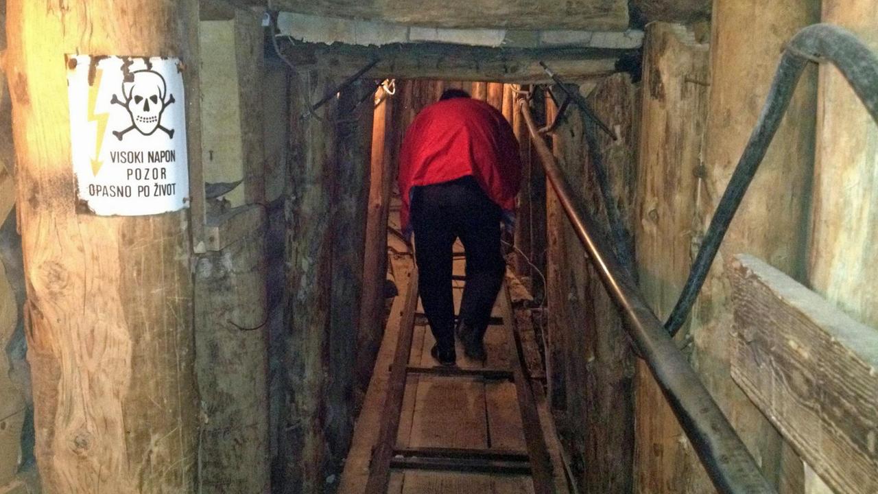 Ein Tourist läuft in den noch erhaltenen Teil des Tunnels in Sarajevo, der im Bosnienkrieg den belagerten Teil der Stadt mit dem befreiten Stadtteil Butmir verband