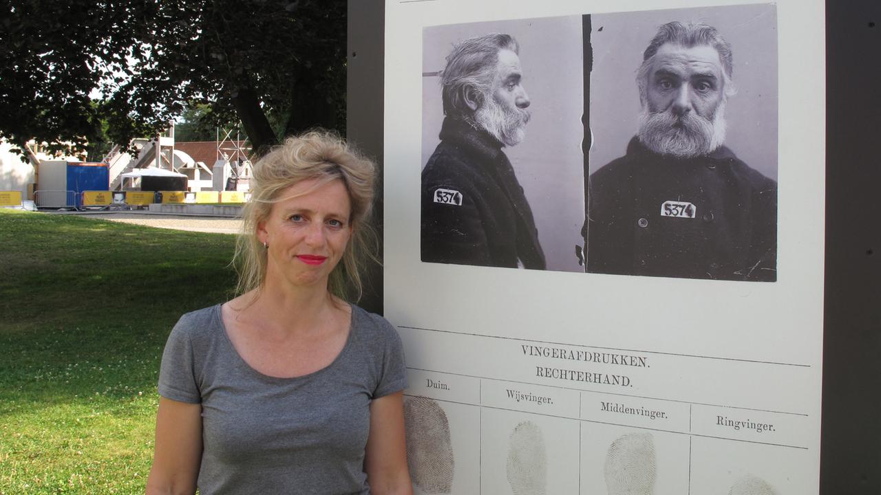 Die niederländische Journalistin Suzanna Jansen vor dem Porträt ihres Urgroßvaters im Innenhof der Besserungsanstalt Veenhuizen, die heute ein Museum ist.