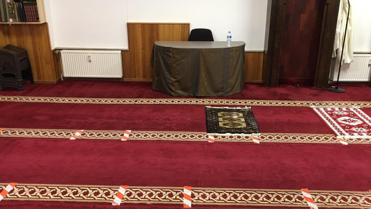 Rot-weiße Klebestreifen markieren im Gebetsraum der El-Iman-Moschee in Hamburg, wieviel Abstand die Gläubigen beim Gebet voneinander halten sollen. Rot-weiße Klebestreifen markieren im Gebetsraum der El-Iman-Moschee in Hamburg, wieviel Abstand die Gläubigen beim Gebet voneinander halten sollen.