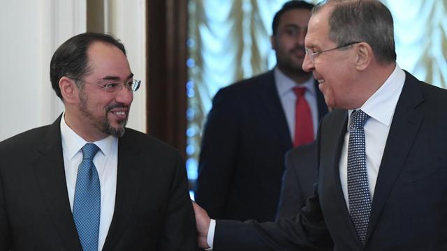Der russische Außenminister Sergej Lawrow (r) legt seine rechte Hand auf den linken Arm seines afghanischen Kollegen Salahuddin Rabbani. Die beiden lächeln sich an.