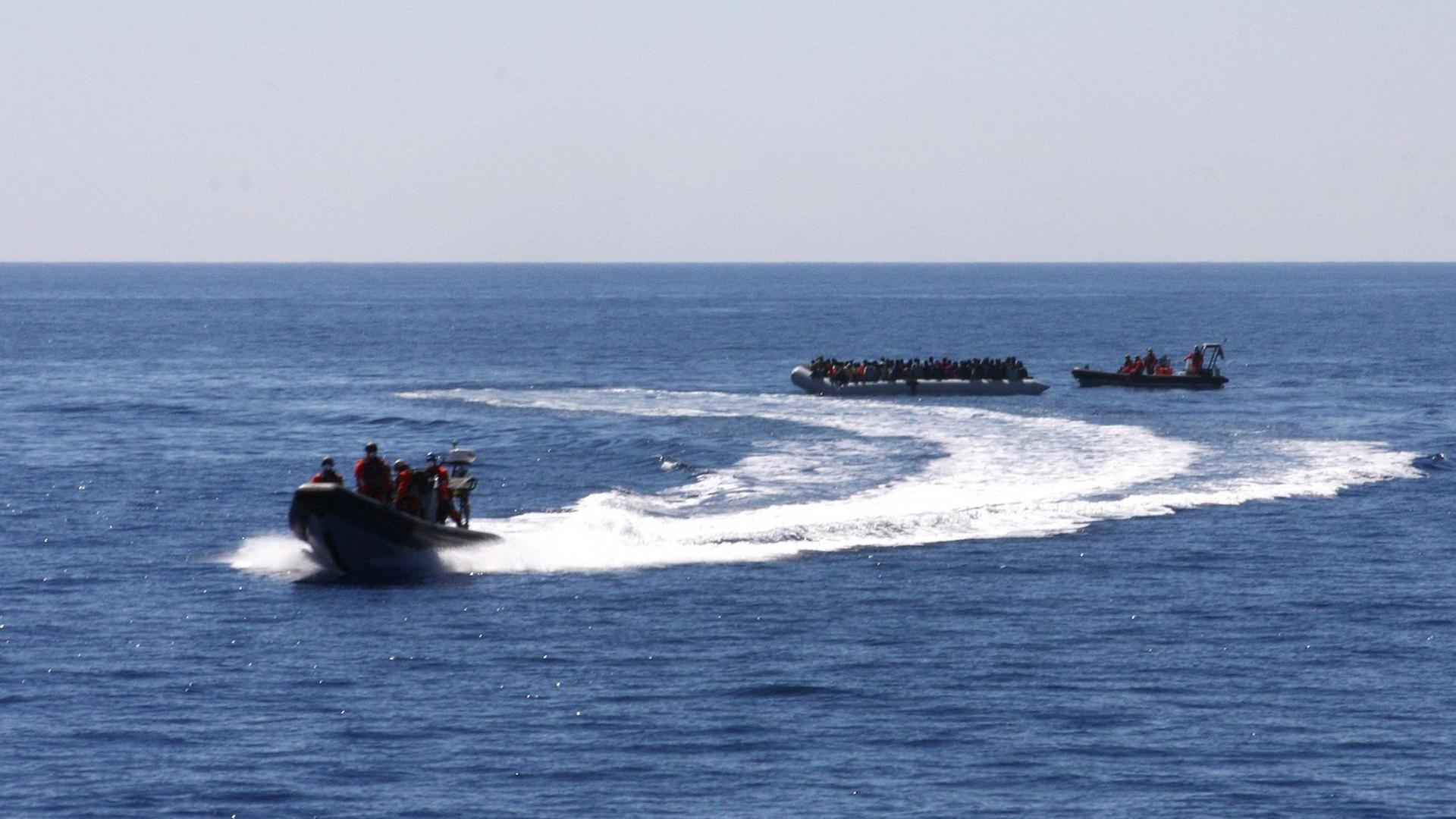 Ein Speedboat und ein Fast Rescue Boat begleiten am 14.05.2015 ein Schlauchboot mit schiffbrüchigen Flüchtlingen zur Fregatte Hessen.