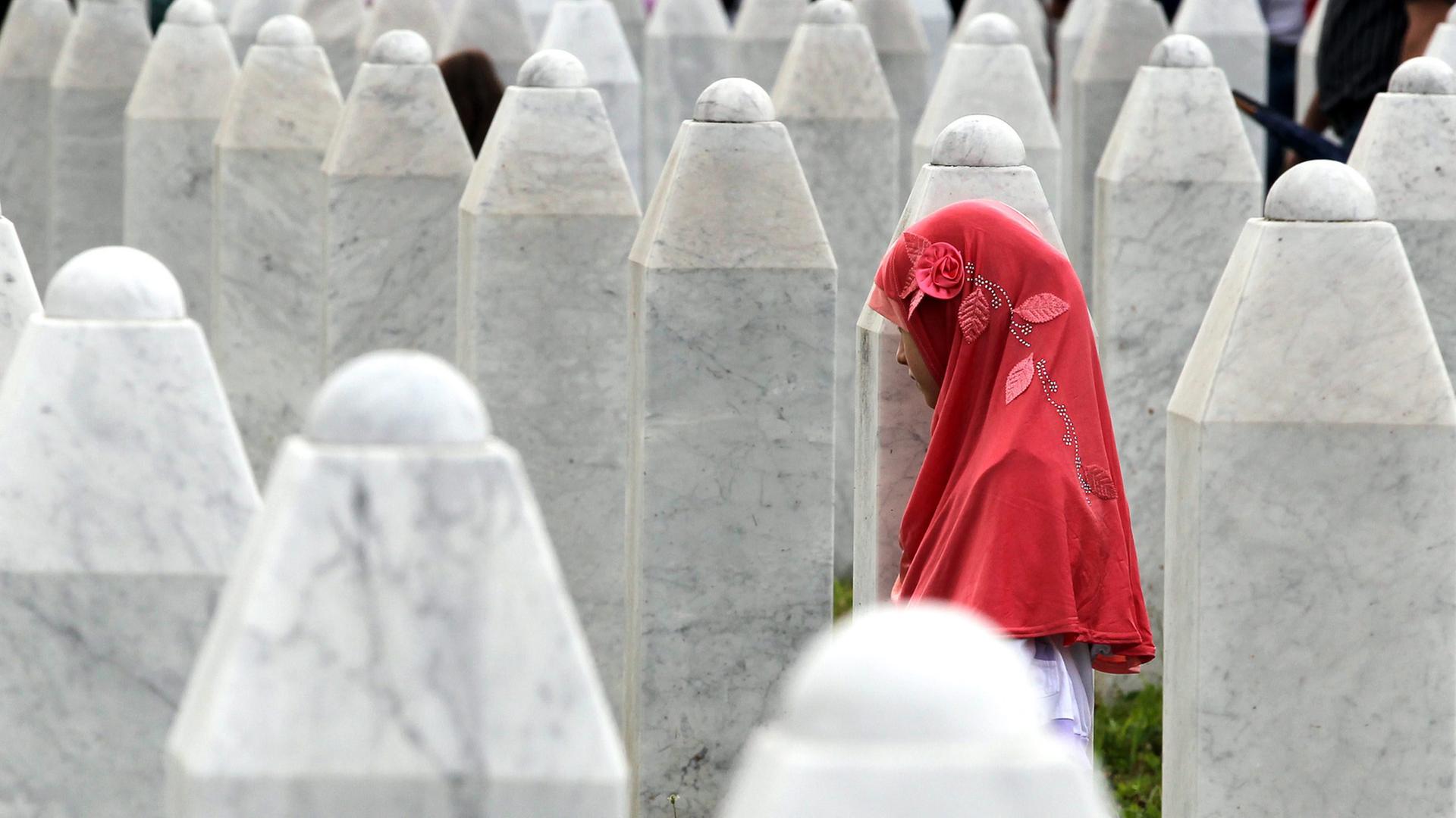 Eine Frau steht an der Gedenkstätte in Srebrenica in Erinnerung an die Opfer von Bosnien im Jahre 1995. Eine Frau steht an der Gedenkstätte in Srebrenica in Erinnerung an die Opfer von Bosnien im Jahre 1995.