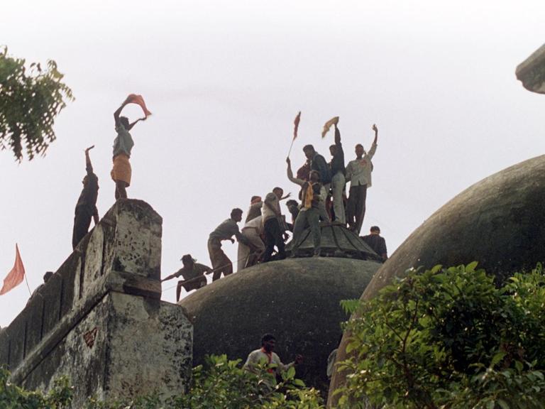 Jubelnde Hindus auf der Kuppel der eroberten Moschee. Radikale Hindus zerstörten am 6. Dezember 1992 die 1528 erbaute Babri-Moschee in Ayodhya im indischen Bundesstaat Uttar Pradesh, um an deren Stelle zu Ehren des Hindu-Gottes Rama einen Tempel zu errichten. Die dadurch entstandenen Unruhen forderten im ganzen Land rund 1200 Menschenleben. (Bild: picture-alliance / dpa)