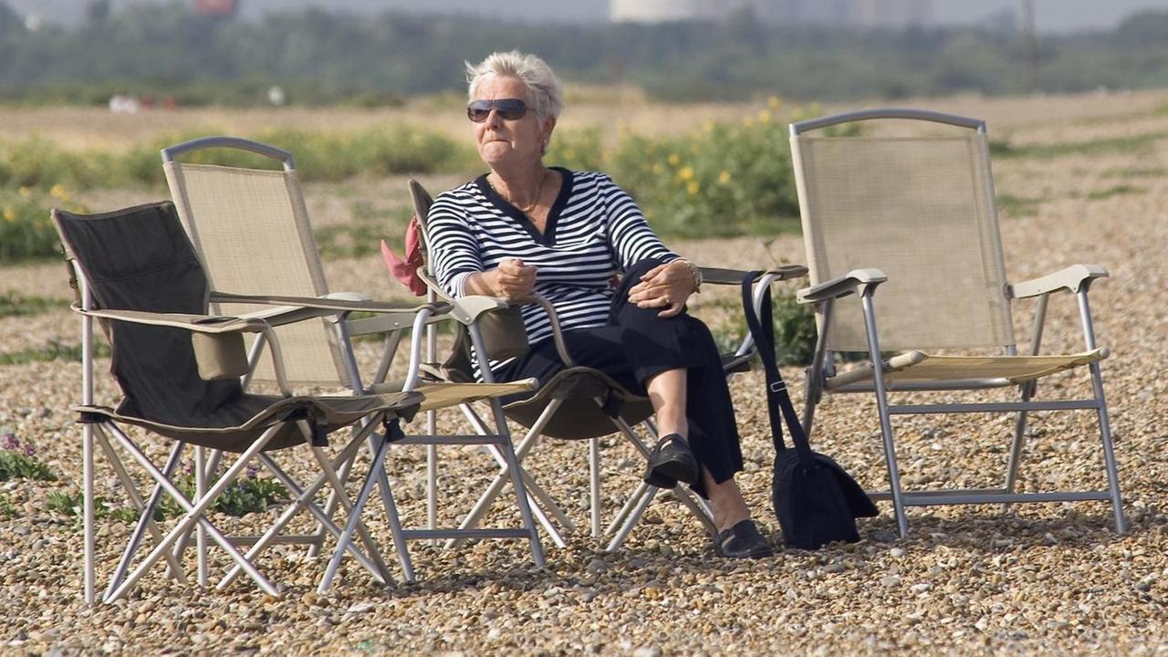 Eine Frau sitzt am Strand von Aldeburgh in Großbritannien auf einem Klappstuhl und genießt die Sonne, aufgenommen im Juli 2005. Eine Frau sitzt am Strand von Aldeburgh in Großbritannien auf einem Klappstuhl und genießt die Sonne, aufgenommen im Juli 2005.