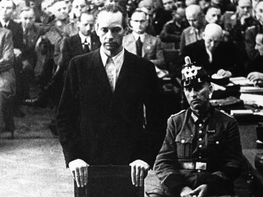 Graf York von Wartenburg vor dem NS-Volksgerichtshof in Berlin, im Hintergrund Zuschauer des Prozesses.