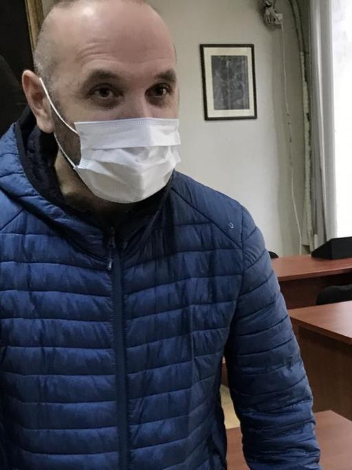 Simon Jangulashvili mit Maske, Handschuhen und Partitur im Lesesaal des Handschriftenzentrums