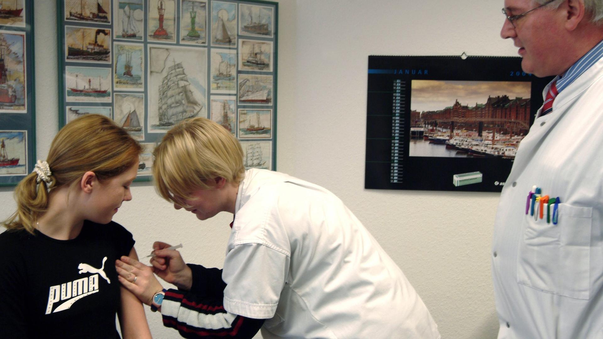 Eine Patientin wird in der Praxis eines Hausarztes (r) vor einer Reise ins Ausland von der Sprechstundenhilfe geimpft. Eine Patientin wird in der Praxis eines Hausarztes (r) vor einer Reise ins Ausland von der Sprechstundenhilfe geimpft.