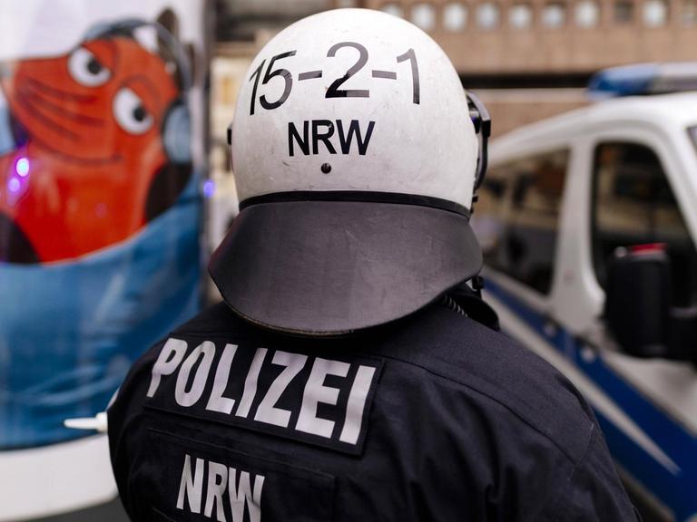 Polizisten schützen Demonstranten gegen den WDR bei den Protesten gegen das von einem Kinderchor gesungene Satire-Lied "Meine Oma ist ne alte Umweltsau" von WDR2 am WDR-Gebäude in der Breite Straße in Köln.