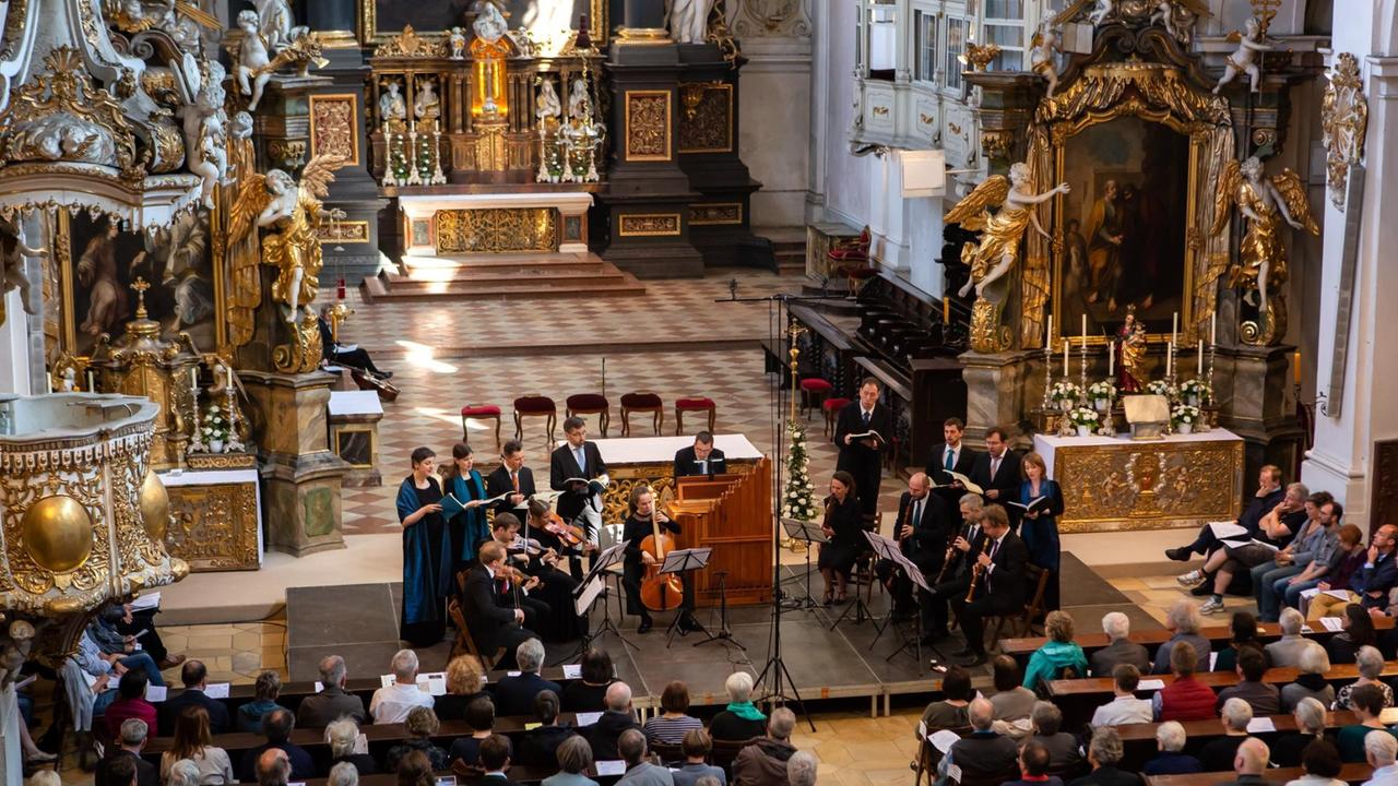 Das Ensemble Vox Luminis in der im Barock neu ausgestalteten Basilika St. Emmeran in Regensburg, die Sängerinnen und Sänger gruppieren sich um die Instrumente im Halbkreis. Das Ensemble Vox Luminis in der im Barock neu ausgestalteten Basilika St. Emmeran in Regensburg, die Sängerinnen und Sänger gruppieren sich um die Instrumente im Halbkreis.