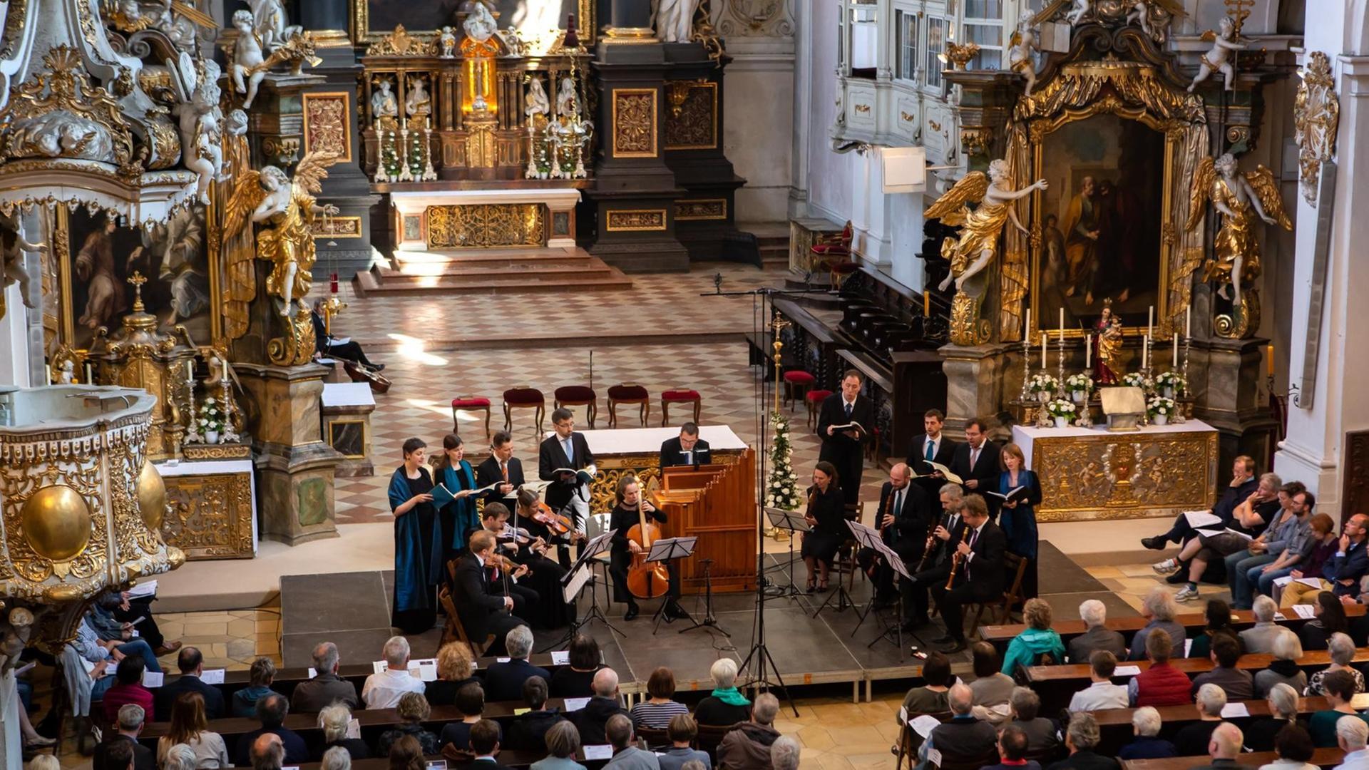 Das Ensemble Vox Luminis in der im Barock neu ausgestalteten Basilika St. Emmeram in Regensburg, die Sängerinnen und Sänger gruppieren sich um die Instrumente im Halbkreis. Das Ensemble Vox Luminis in der im Barock neu ausgestalteten Basilika St. Emmeram in Regensburg, die Sängerinnen und Sänger gruppieren sich um die Instrumente im Halbkreis.