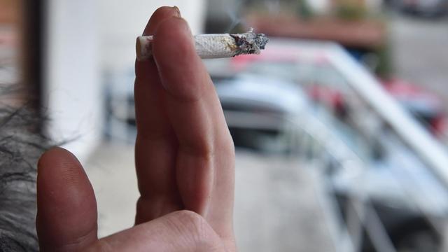 Eine Frau raucht am 15.01.2015 in Karlsruhe (Baden-Württemberg) auf einem Balkon eine Zigarette.