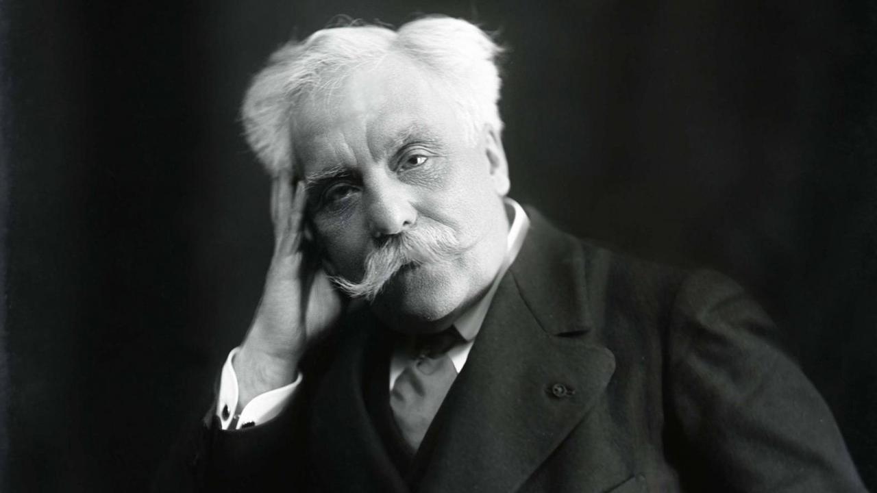 Schwarz-weiß Fotografie des Komponisten Gabriel Fauré (1845-1924), er hat weiße Haare und einen weißen Schnurbart, er trägt eine schwarze Anzugjacke mit breitem Revers, ein weißes Hemd und einen dunklen Schlips, er schaut in dei Kamera und hat seinen Kopf auf die rechte Hand gestützt Schwarz-weiß Fotografie des Komponisten Gabriel Fauré (1845-1924), er hat weiße Haare und einen weißen Schnurbart, er trägt eine schwarze Anzugjacke mit breitem Revers, ein weißes Hemd und einen dunklen Schlips, er schaut in dei Kamera und hat seinen Kopf auf die rechte Hand gestützt