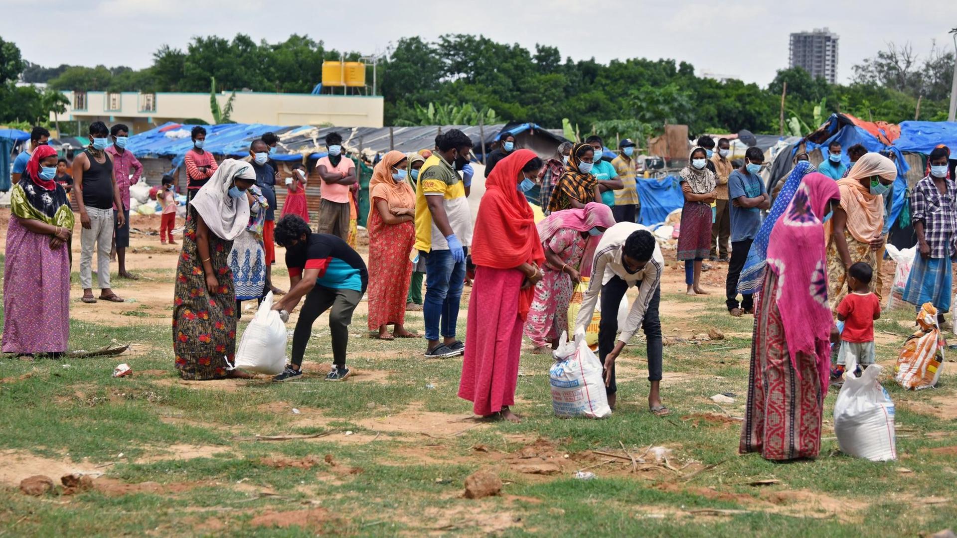 Rohingya-Flüchtlinge erhalten in einem Lager in Bengaluru in Indien Nahrungsmittel. Rohingya-Flüchtlinge erhalten in einem Lager in Bengaluru in Indien Nahrungsmittel.