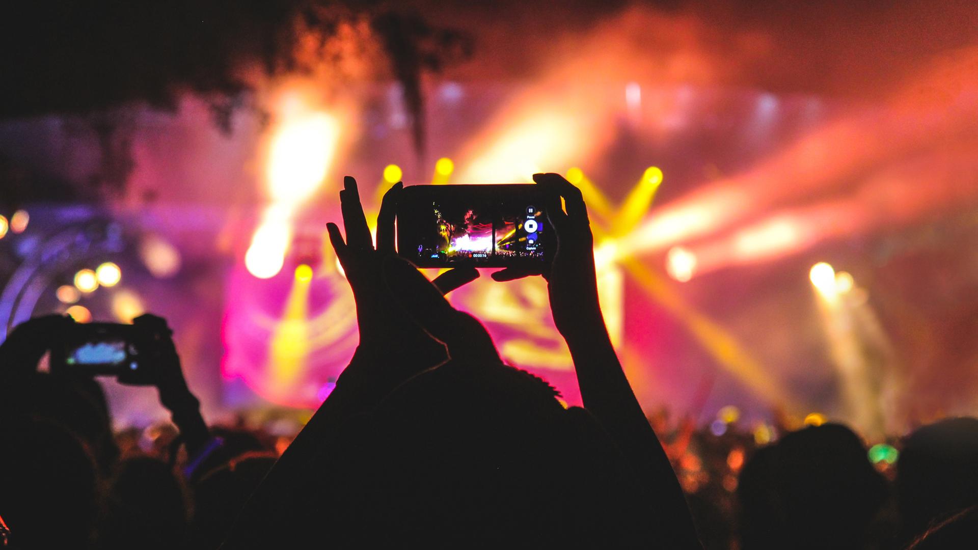 Konzertbesucher filmen die Band mit dem Handy. Konzertbesucher filmen die Band mit dem Handy.