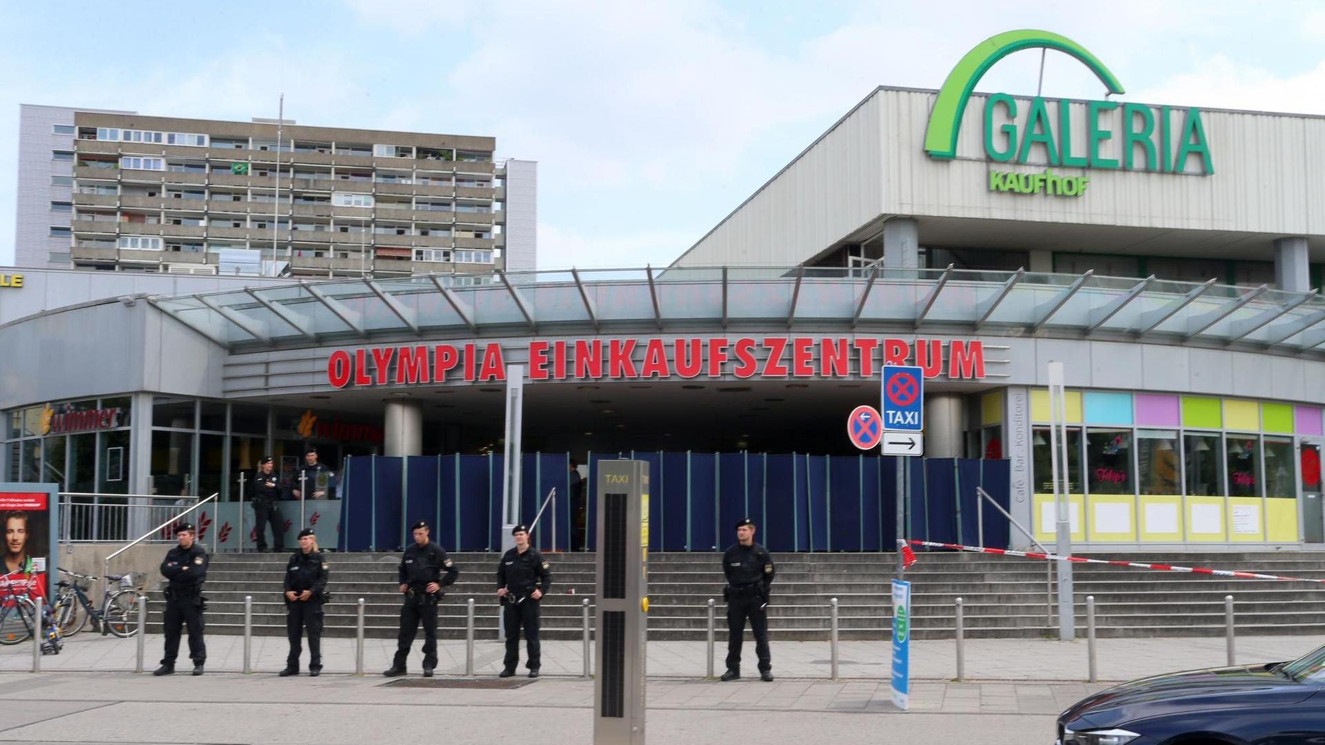 Polizeibeamte stehen am 23.07.2016 vor dem Olympia-Einkaufszentrum OEZ in München (Bayern), einen Tag nach einer Schießerei mit Toten und Verletzten.
