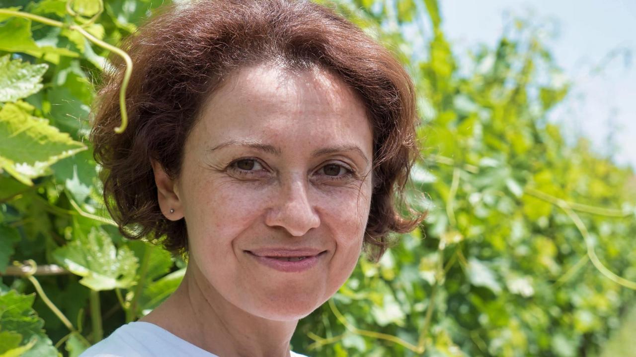 Karine Zakharyan im Porträt, im Hintergrund Weinpflanzen