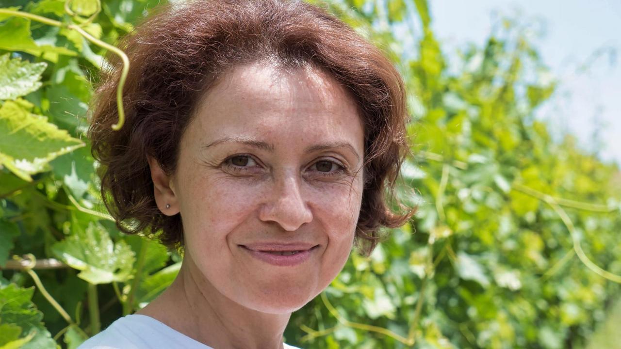 Karine Zakharyan im Porträt, im Hintergrund Weinpflanzen Karine Zakharyan im Porträt, im Hintergrund Weinpflanzen