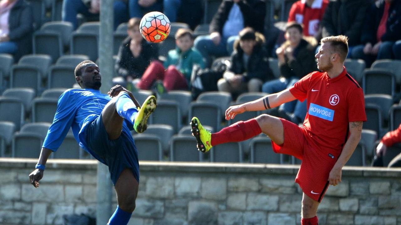 Aris Kukanda vom TuS Makkabi und Philipp Grüneberg vom SV Lichtenberg im Zweikampf um den Ball. Beide schwingen das rechte Bein in die Luft, hin zum Ball. Aris Kukanda vom TuS Makkabi und Philipp Grüneberg vom SV Lichtenberg im Zweikampf um den Ball. Beide schwingen das rechte Bein in die Luft, hin zum Ball.