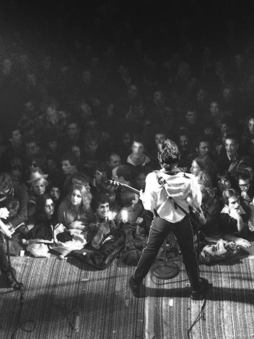 Blick von oben auf die Bühne. The Clash im Vordergrund, im Hintergrund das Publikum.