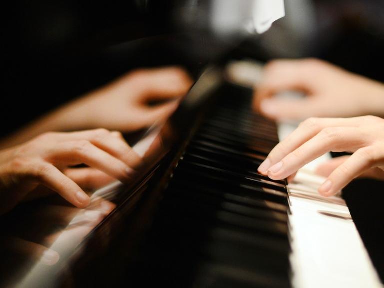 Ein Pianist spielt auf den Tasten eines Klaviers.