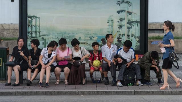 Menschen warten an einer Bushaltestelle in Pjöngjang (Nordkorea)