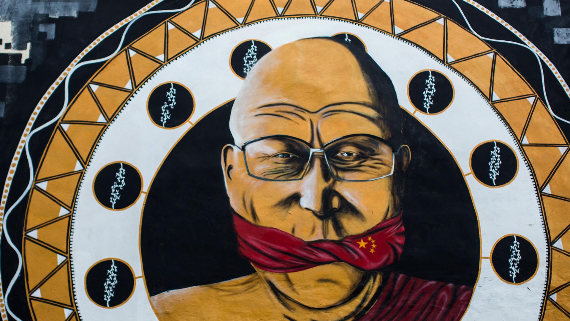Ein Wandgemälde zeigt am 13.04.2013 in Köln (Nordrhein-Westfalen) das geistliche Oberhaupt des Tibetischen Buddhismus, den Dalai Lama, der mit einer chinesischen Flagge geknebelt ist. Das elf Meter hohe Gemälde mit dem Motto "Reden ist silber, schweigen ist China", das der Kölner Streetart-Künstler B. Shanty gemalt hat, hatte die Kölner Gruppe von Amnesty International in Auftrag gegeben.
