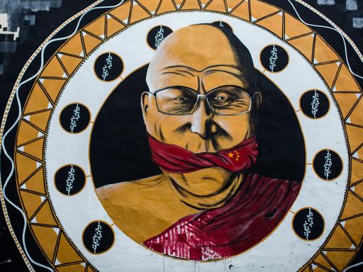 Ein Wandgemälde zeigt am 13.04.2013 in Köln (Nordrhein-Westfalen) das geistliche Oberhaupt des Tibetischen Buddhismus, den Dalai Lama, der mit einer chinesischen Flagge geknebelt ist. Das elf Meter hohe Gemälde mit dem Motto "Reden ist silber, schweigen ist China", das der Kölner Streetart-Künstler B. Shanty gemalt hat, hatte die Kölner Gruppe von Amnesty International in Auftrag gegeben.