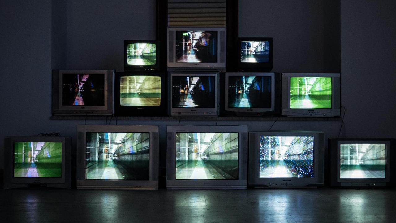 Vernissage der "TV WALL digital to analog" Ausstellung in der Kunstgalerie Scheier, Kroatien, eine Pyramide aus laufenden Fernsehgeräten steht in einem abgedunkelten Raum. Vernissage der "TV WALL digital to analog" Ausstellung in der Kunstgalerie Scheier, Kroatien, eine Pyramide aus laufenden Fernsehgeräten steht in einem abgedunkelten Raum.