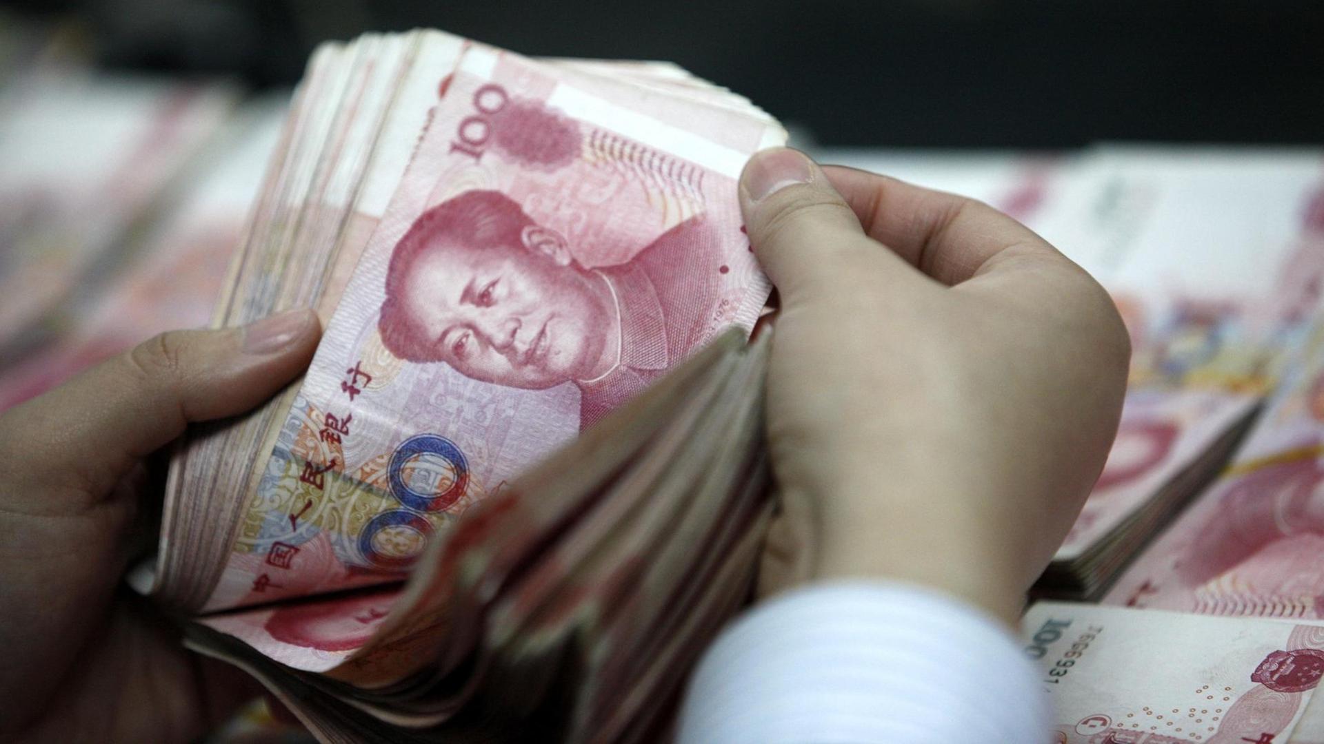 Ein Mensch in China zählt Yuan-Scheine Ein Mensch in China zählt Yuan-Scheine