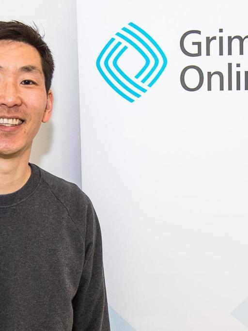 Frank Joung vor einem "Grimme Online Award"-Banner von der Bekanntgabe der Nominierungen zum Grimme Online Award 2018 am 26. April im "Startplatz" in Köln.