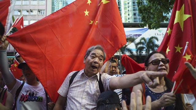 Proetstierende für und gegen die Zentralregierung in Peking protestieren in Hongkong im Vorfeld zu den Feierlichkeiten zum 20. Jahrestag der Rückgabe an China.