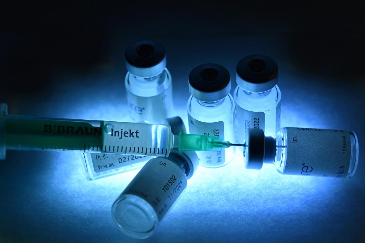 Eine Einwegspritze und Impfdosen mit Impfstoff zur Injektion mit einer Kanüle.