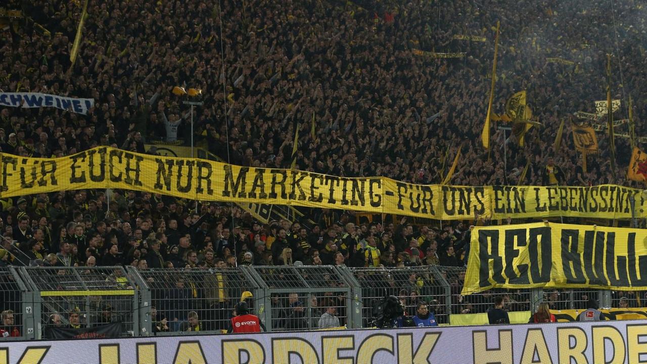 Dortmunder Fans zeigen während des Spieles Borussia Dortmund gegen RB Leipzig im Signal-Iduna-Park Transparente mit der Aufschrift "Für Euch nur Marketing - Für uns ein Lebenssinn" und "Red Bull - Feind des Fußballs". Dortmunder Fans zeigen während des Spieles Borussia Dortmund gegen RB Leipzig im Signal-Iduna-Park Transparente mit der Aufschrift "Für Euch nur Marketing - Für uns ein Lebenssinn" und "Red Bull - Feind des Fußballs".