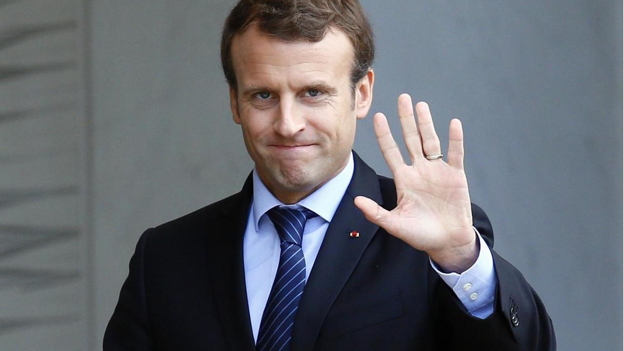 Frankreichs Staatspräsident Emmanuel Macron winkt in die Kamera. Frankreichs Staatspräsident Emmanuel Macron winkt in die Kamera.