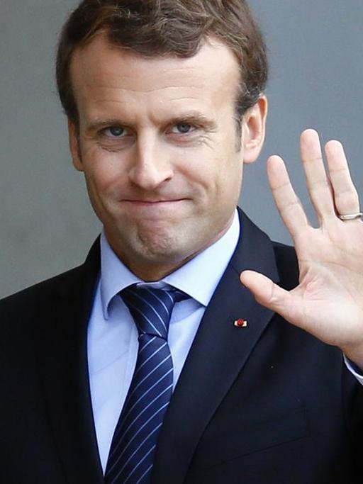 Frankreichs Staatspräsident Emmanuel Macron winkt in die Kamera.