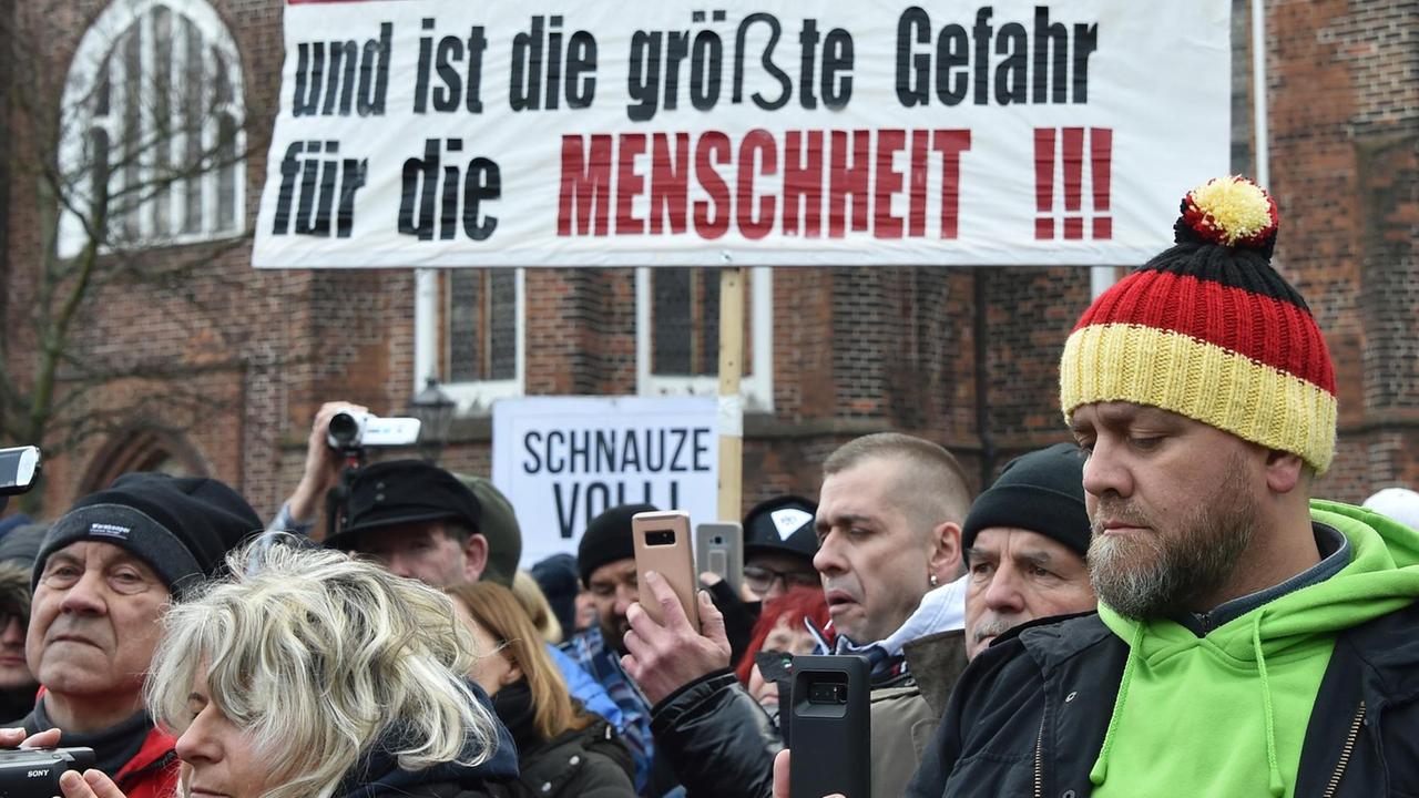 Vor dem Plakat "Die Islamisierung ist wie ein Krebsgeschwür und ist die größte Gefahr für die Menschheit" stehen Demonstranten auf dem Oberkirchplatz. Der Verein Zukunft Heimat e.V. hatte zu der Demonstration aufgerufen. Foto: Bernd Settnik/dpa-Zentralbild/dpa | Verwendung weltweit Vor dem Plakat "Die Islamisierung ist wie ein Krebsgeschwür und ist die größte Gefahr für die Menschheit" stehen Demonstranten auf dem Oberkirchplatz. Der Verein Zukunft Heimat e.V. hatte zu der Demonstration aufgerufen. Foto: Bernd Settnik/dpa-Zentralbild/dpa | Verwendung weltweit