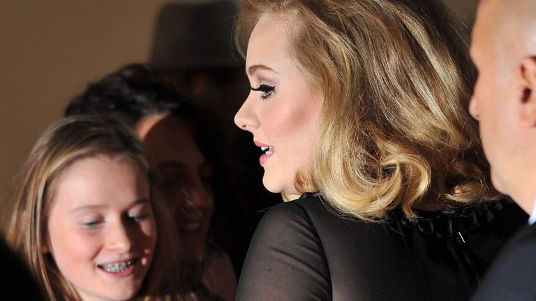 Die Sängerin Adele gibt bei den Brit Awards 2012 ein Autogramm.