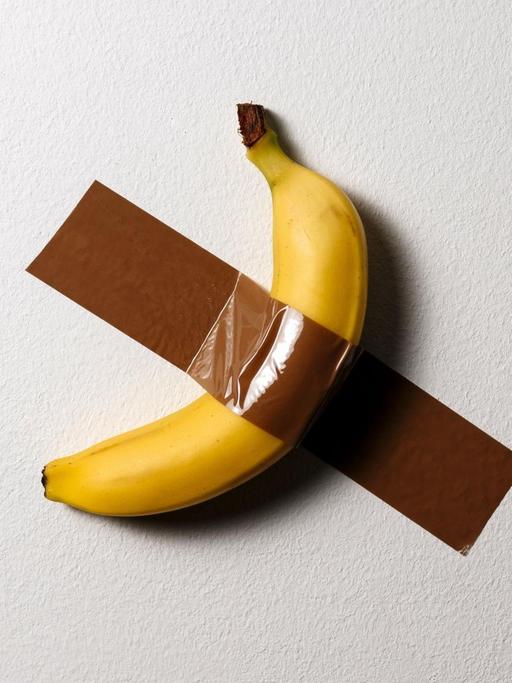 Eine Banane ist mit Klebeband an die Wand geklebt, ähnlich der Installation "Comedian" von Maurizio Cattelan auf der Art Basel.