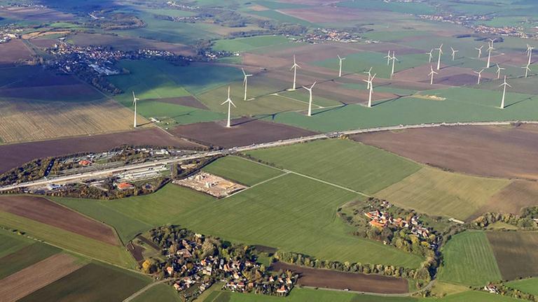 Eine Luftaufnahme von Windrädern zwischen Feldern.