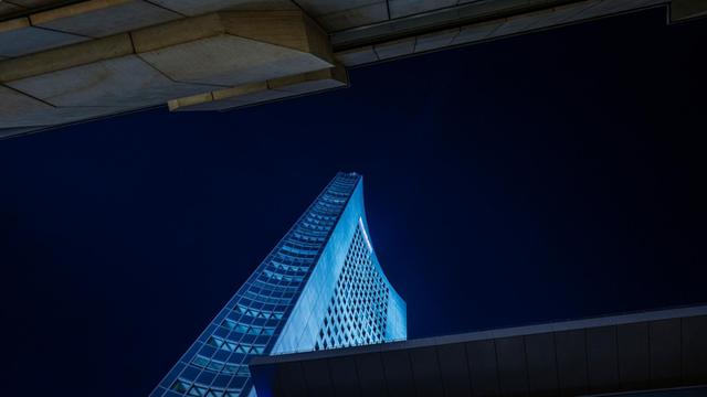 Blau angestrahlter MDR-Turm am Augustusplatz in Leipzig bei Nacht.
