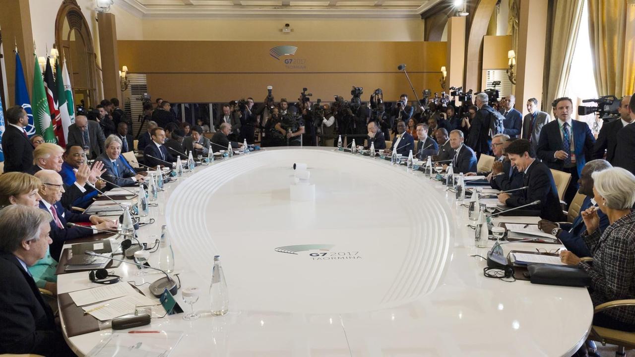 Das Foto zeigt die Staats- und Regierungschefs der sieben größten Industrienationen, G7. Sie beraten sitzend an einem Tisch in großer Runde am zweiten Gipfeltag in Taormina auf Silizien. Das Foto zeigt die Staats- und Regierungschefs der sieben größten Industrienationen, G7. Sie beraten sitzend an einem Tisch in großer Runde am zweiten Gipfeltag in Taormina auf Silizien.