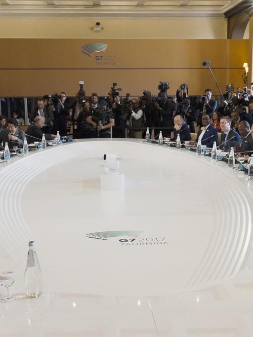 Das Foto zeigt die Staats- und Regierungschefs der sieben größten Industrienationen, G7. Sie beraten sitzend an einem Tisch in großer Runde am zweiten Gipfeltag in Taormina auf Silizien.