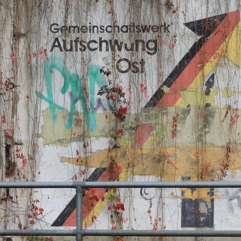 An einer Schallschutzwand in Magdeburg prangt der verwitterte Schriftzug "Gemeinschaftswerk Aufschwung Ost".