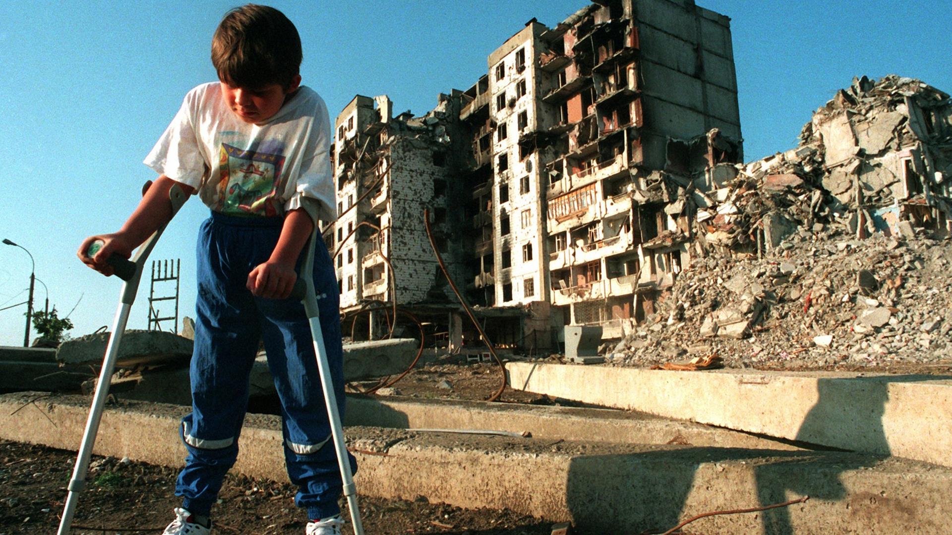 31.7.1995: Der achtjährige tschetschenische Junge Mischa Jepiphantschew geht auf Krücken durch die Straßen von Grosny. 31.7.1995: Der achtjährige tschetschenische Junge Mischa Jepiphantschew geht auf Krücken durch die Straßen von Grosny.