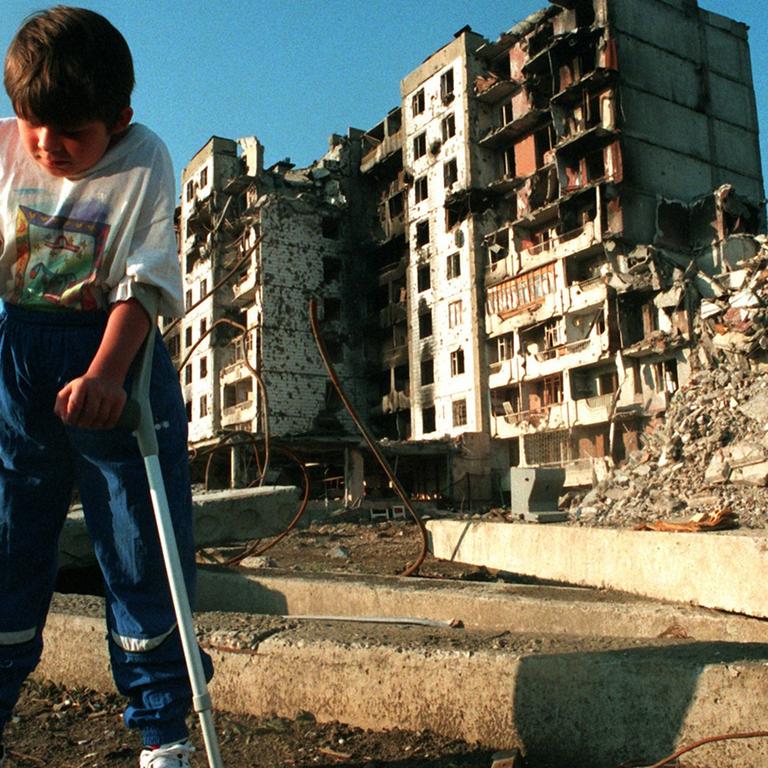 31.7.1995: Der achtjährige tschetschenische Junge Mischa Jepiphantschew geht auf Krücken durch die Straßen von Grosny. 