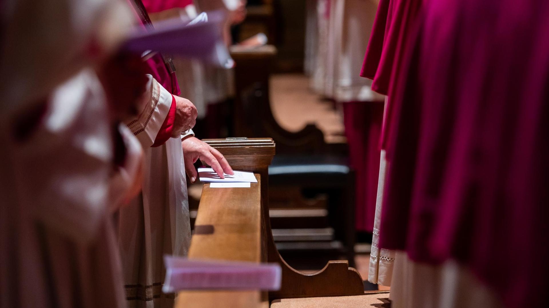 Bischöfe stehen im Gottesdienst in den Kirchenbänken. Bischöfe stehen im Gottesdienst in den Kirchenbänken.