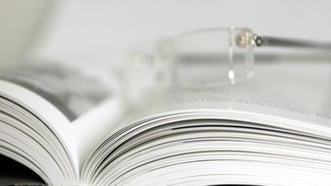 Aufgeschlagenes Buch mit Lesebrille
