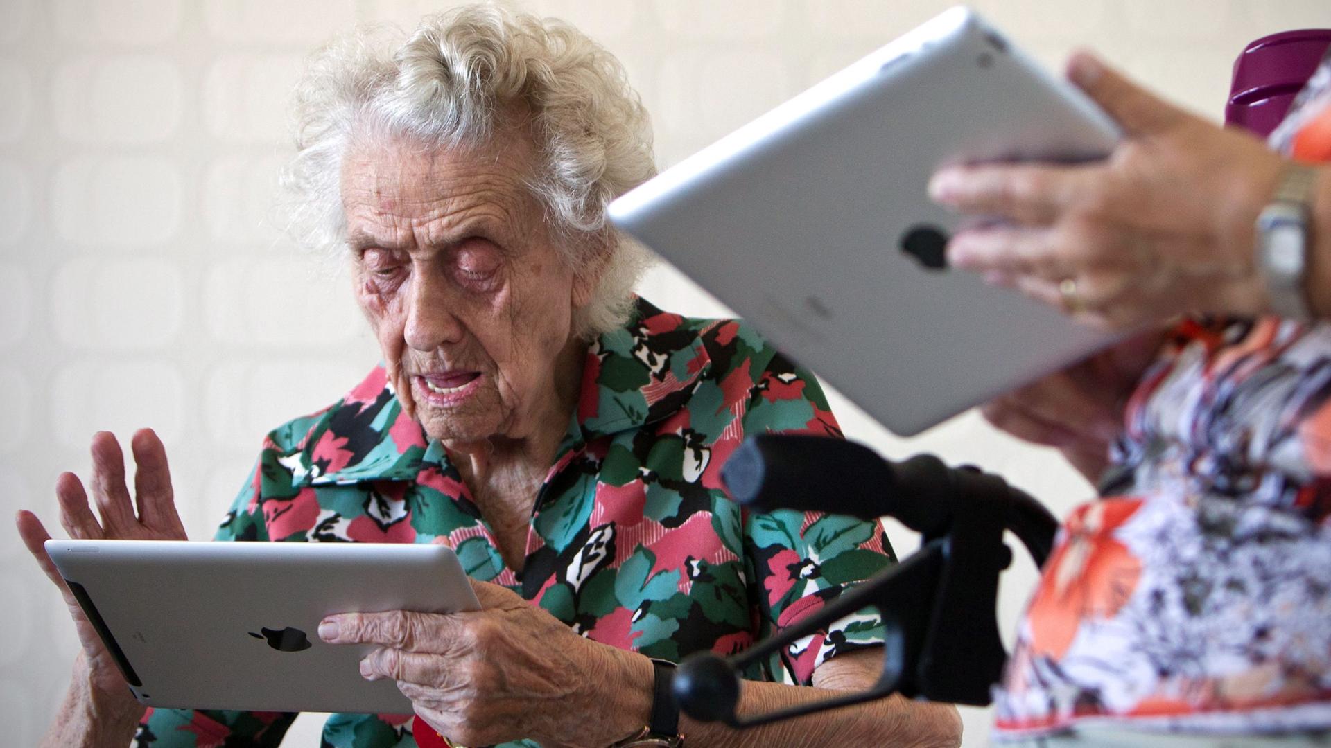 Die Rentnerin Hildegard Weide, Jahrgang 1912, und andere Bewohnerinnen des "Cyber-Hauses 2.0" der Wohnungsbaugenossenschaft "Otto von Guericke" in Magdeburg testet einen Tablet-Computer. Die Rentnerin Hildegard Weide, Jahrgang 1912, und andere Bewohnerinnen des "Cyber-Hauses 2.0" der Wohnungsbaugenossenschaft "Otto von Guericke" in Magdeburg testet einen Tablet-Computer.
